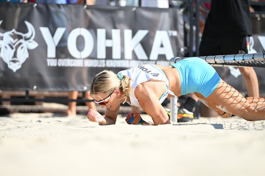 Female athlete crawling under a cargo net