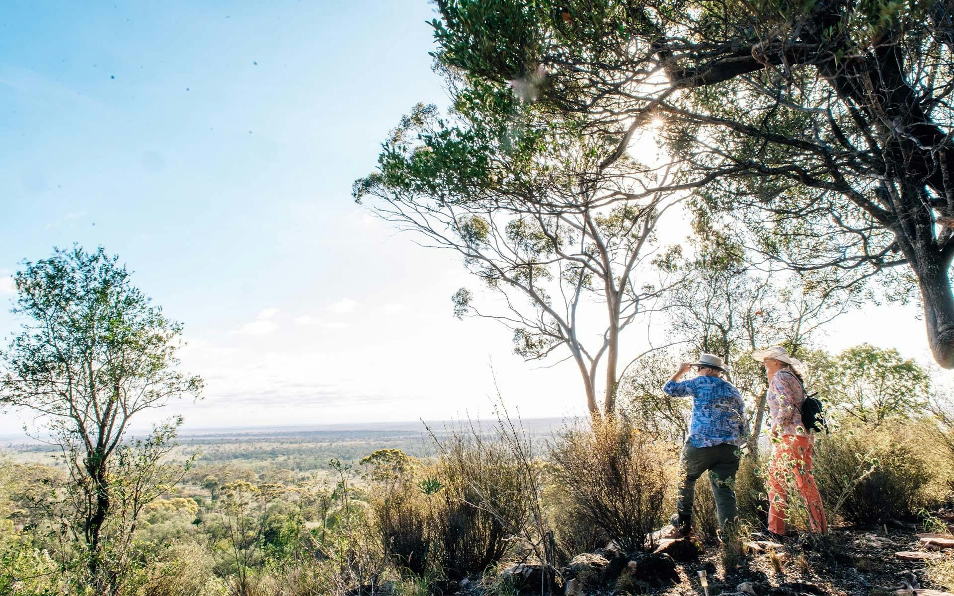 Two people looking out from a cliff face