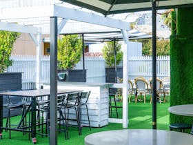 Open air garden area with seating, umbrellas and turf area