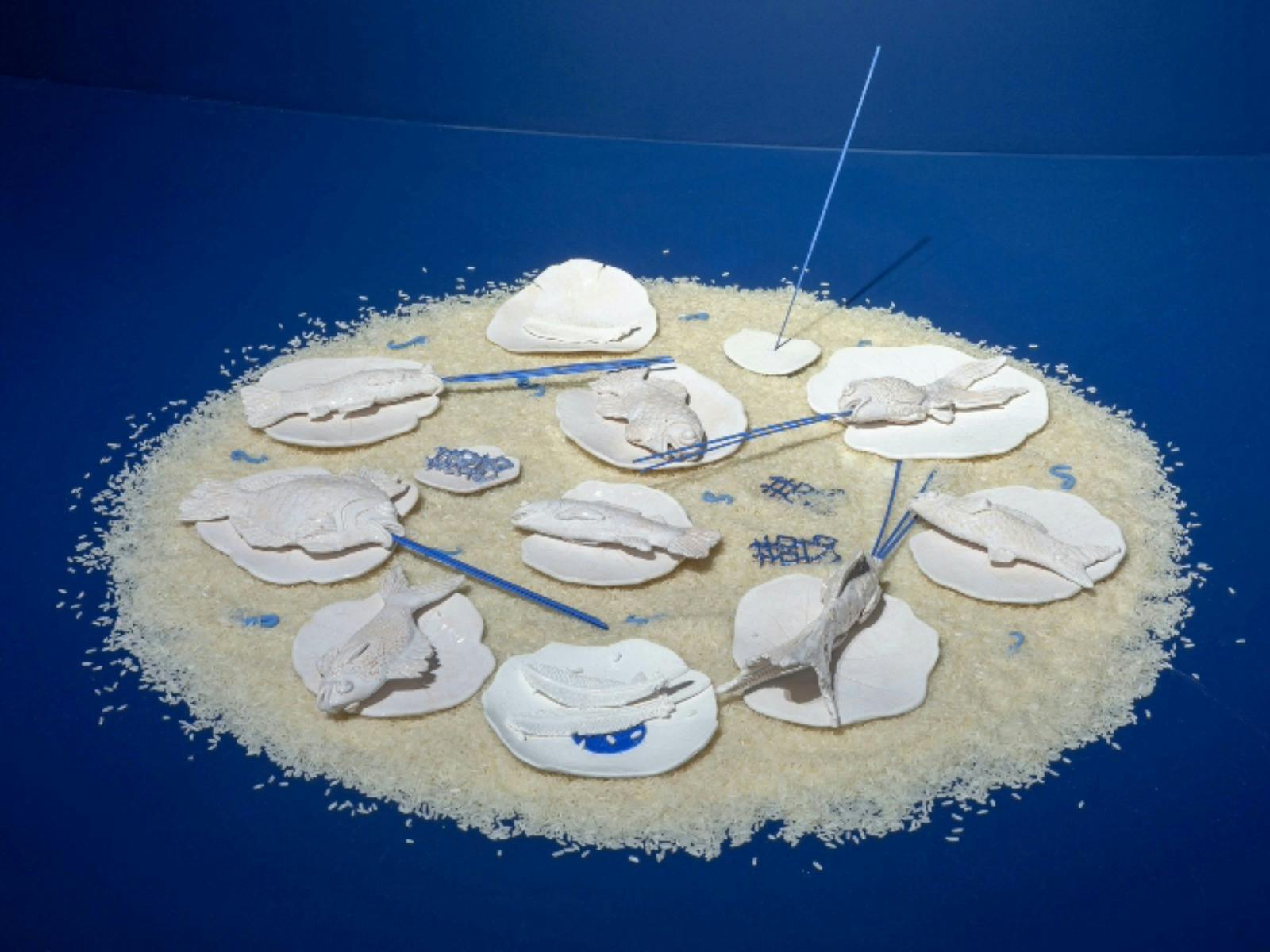Photograph of artwork installation with ceramic fish on plates