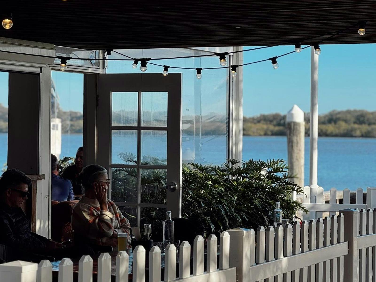 people seated outside with river in background