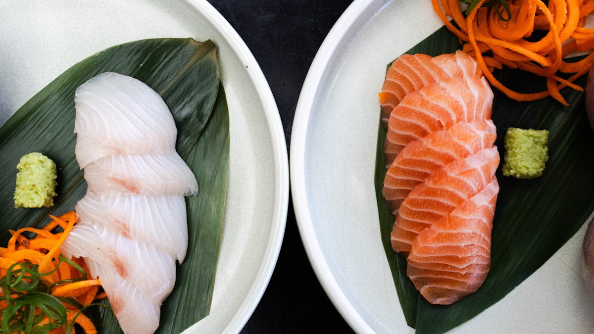 Guests enjoying some salmon and kingfish sashimi with wasabi and soy sauce