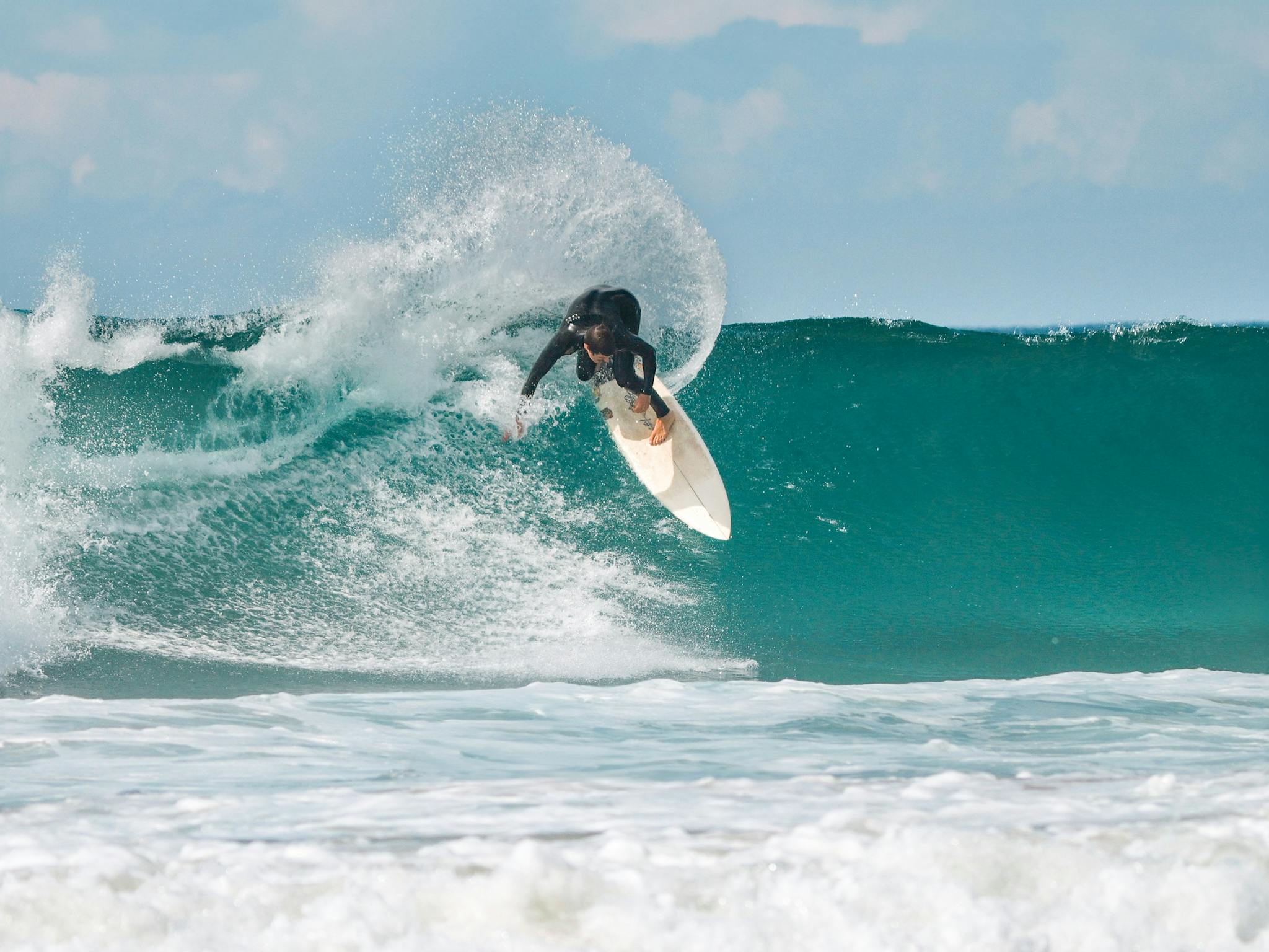 lifestyle shot of a man surfing a wave