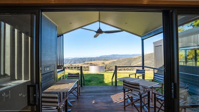 Outdoor deck area with seating overlooking expansive countryside and mountain views.