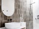Roam Merrijig bathroom with rustic olive tiles, white basin and a walk in shower