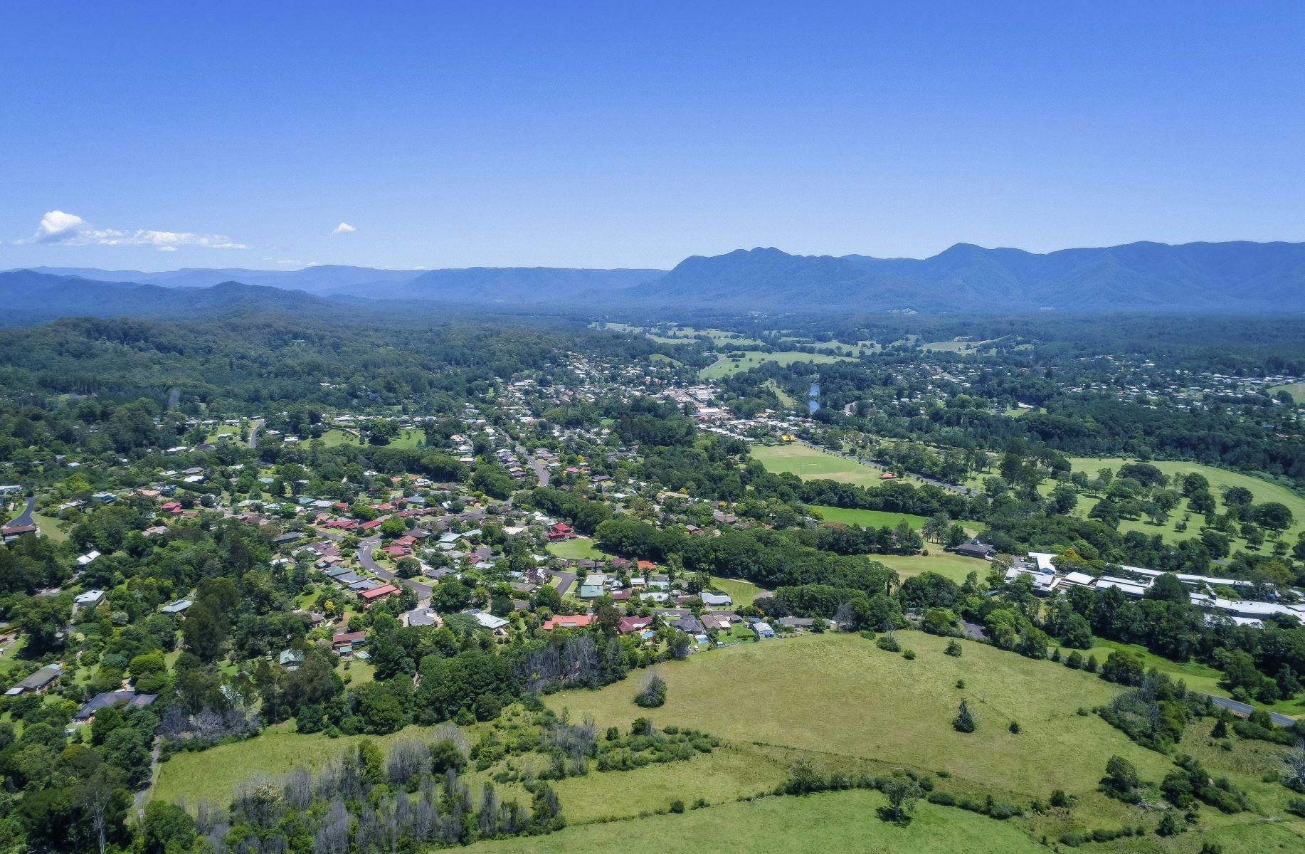 Aerial landscape view of Bellingen Shire: fair amount of greenery, trees and mountains around houses