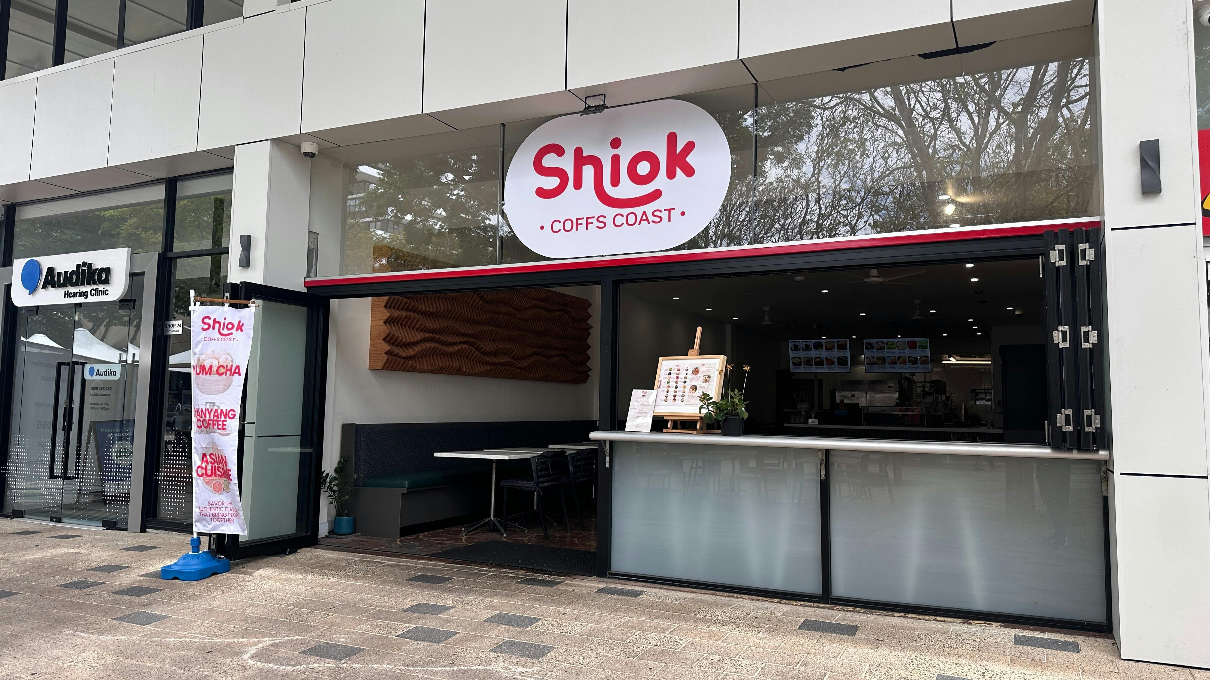 Exterior of Shiok Coffs Coast, an Asian fusion restaurant with red signage and open glass front.