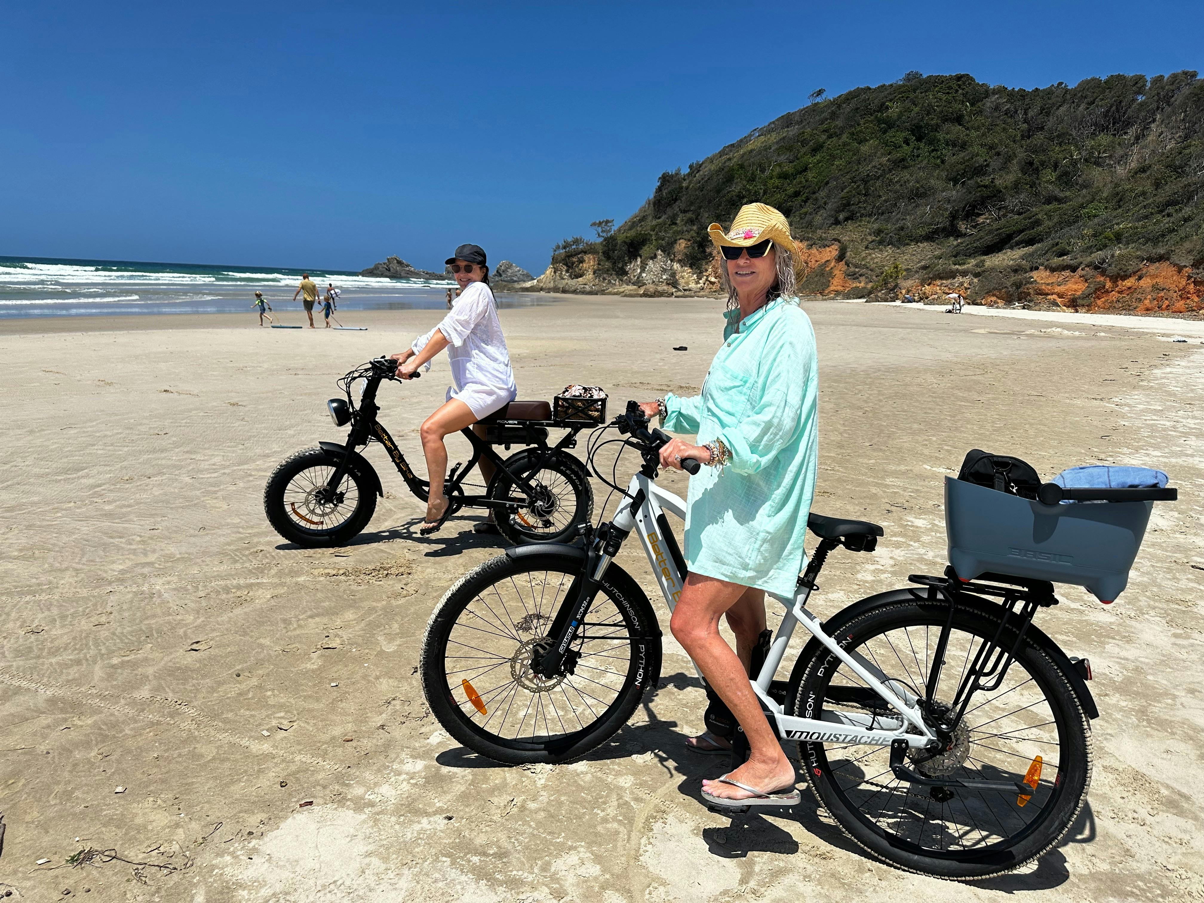 Two riders on ebikes on the beach