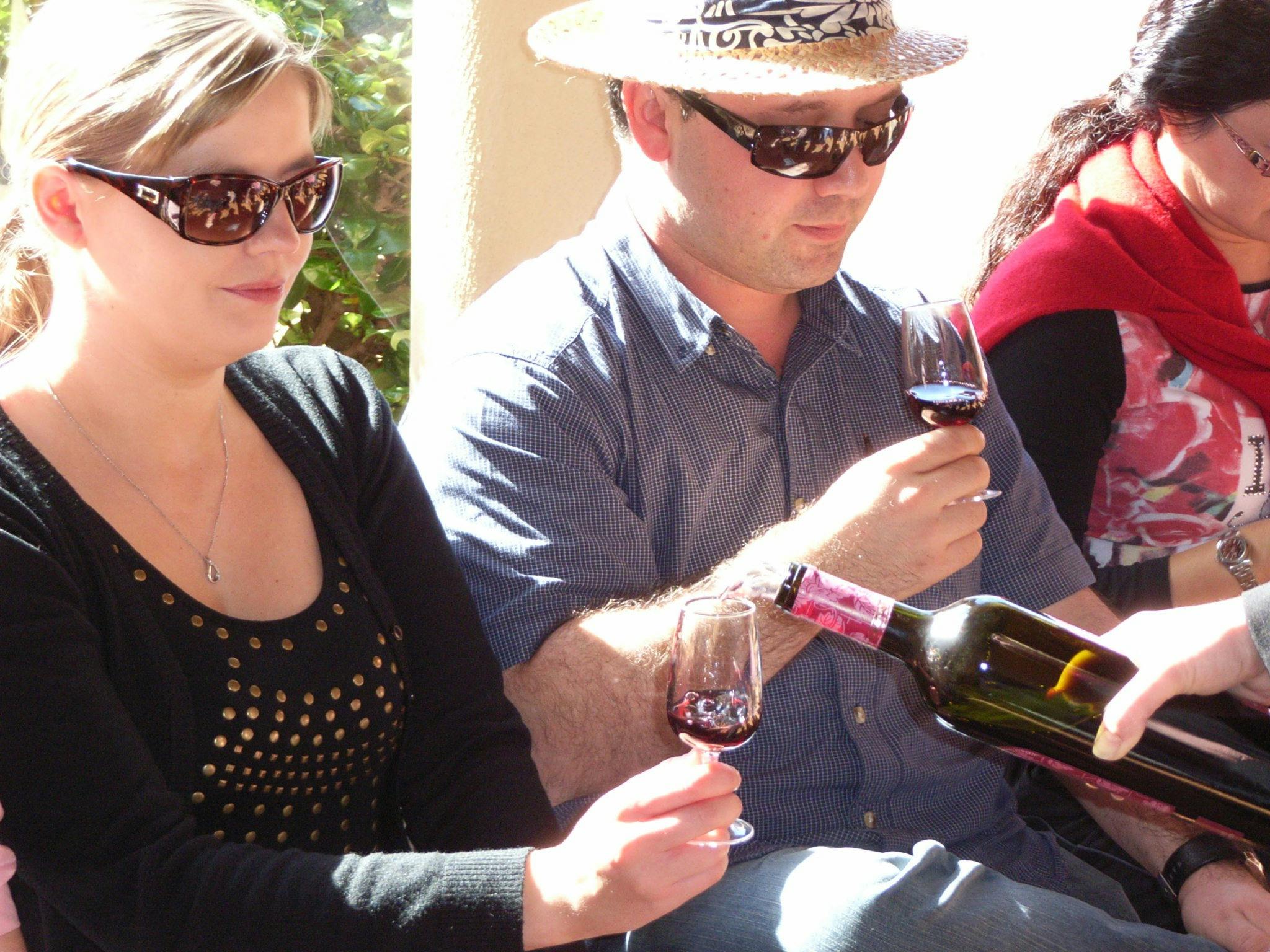 Kleine Gruppe genießt Weinprobe im Freien bei Sonnenschein auf einem Weingut im Hunter Valley