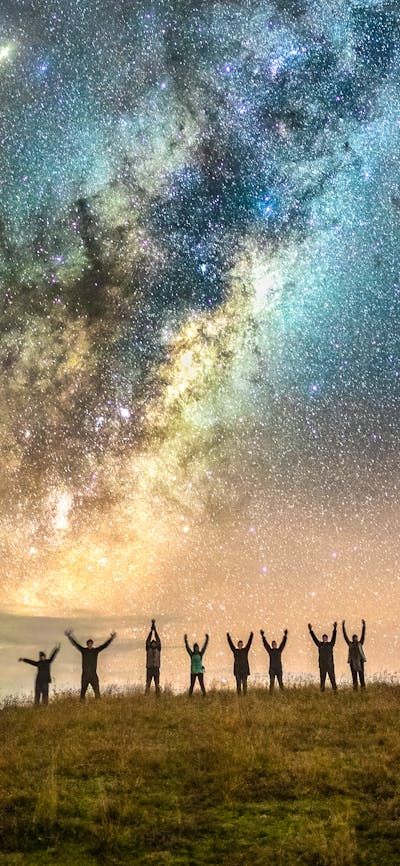 Astrophotographers posing under the Milky Way