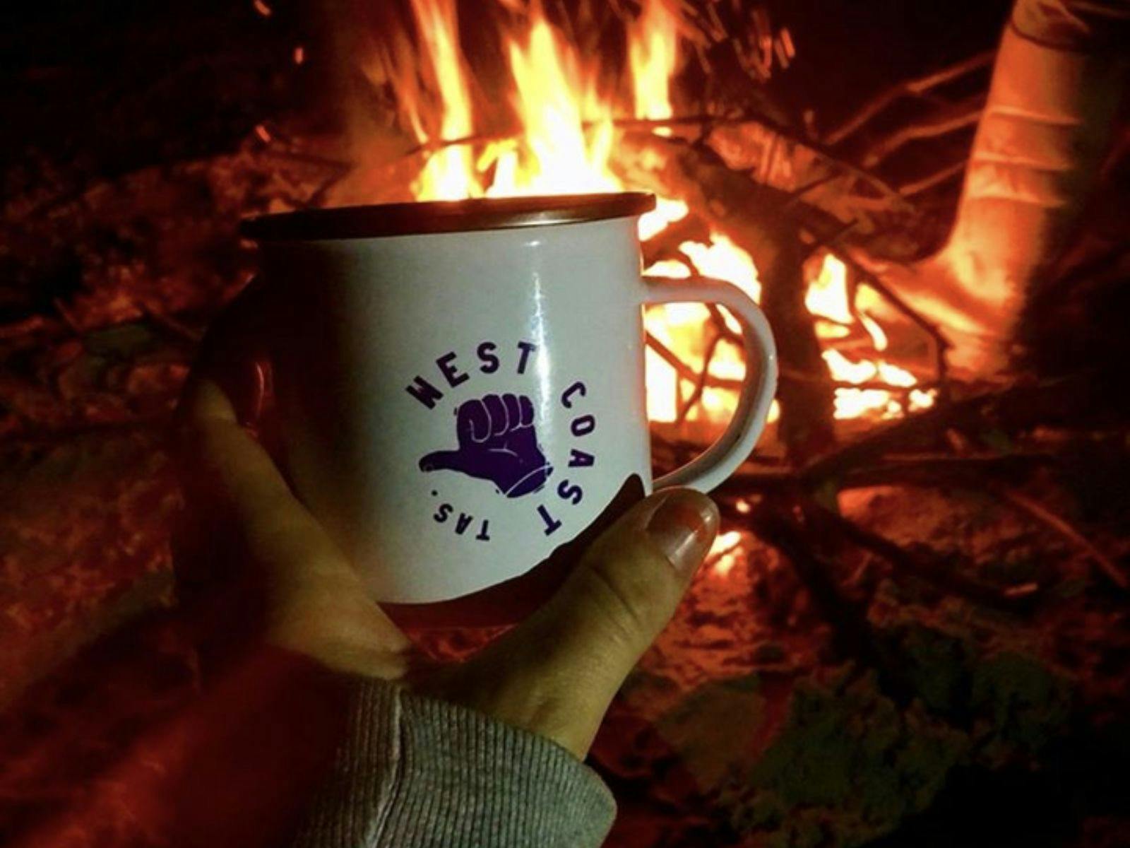 West Coast mug in front of campfire
