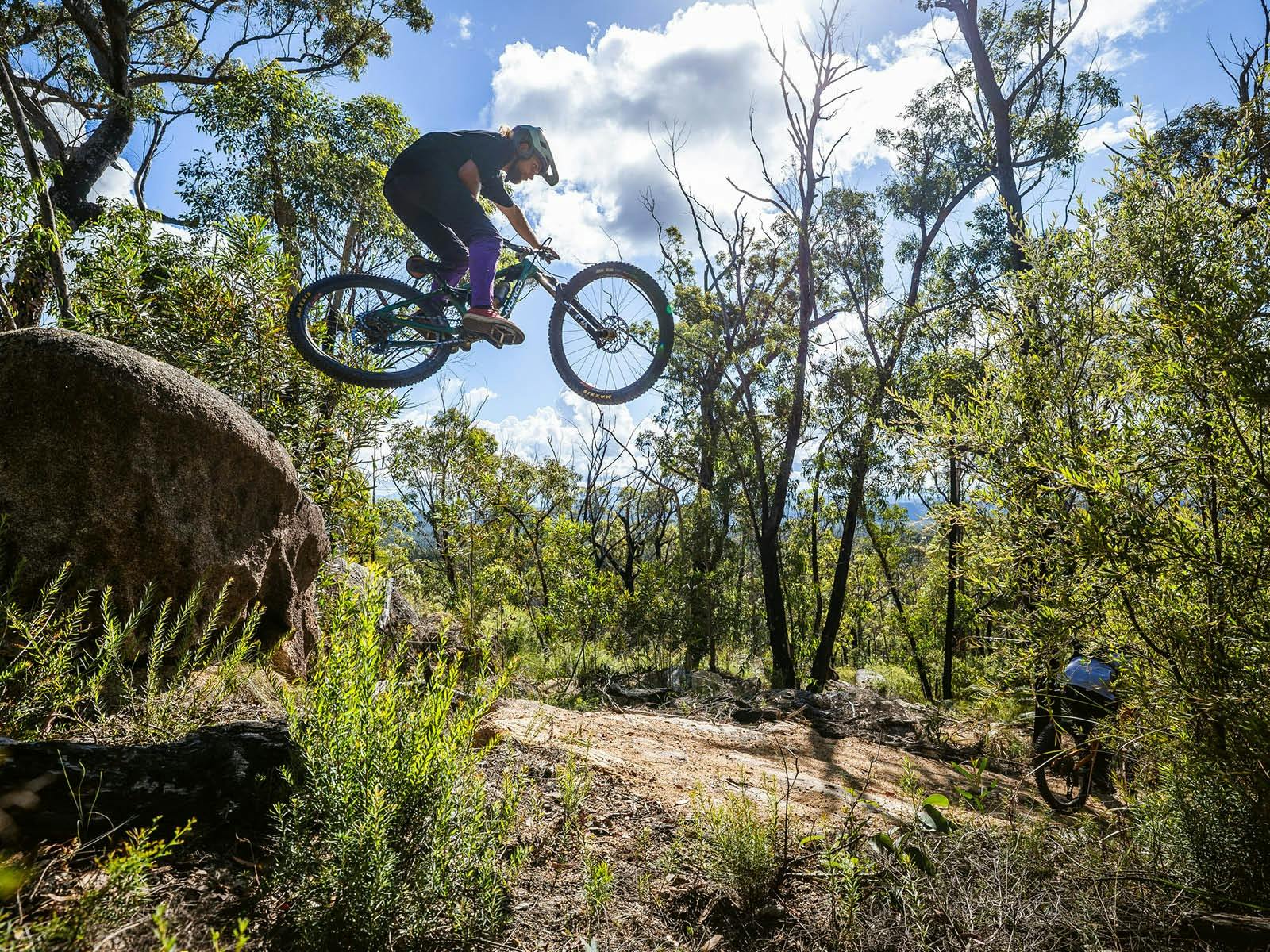 큰 바위 위로 자전거를 점프하는 자전거 타는 사람