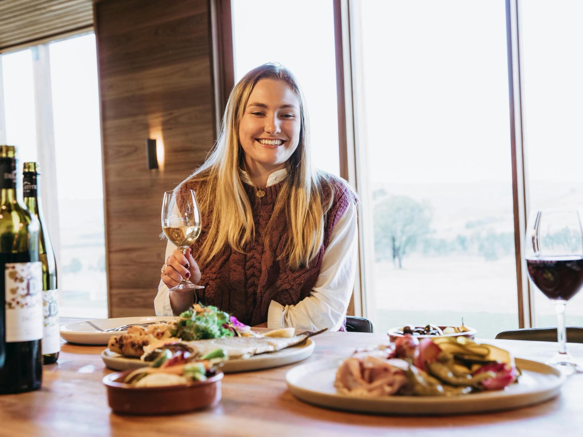 girl enjoying a glass of wine and platters