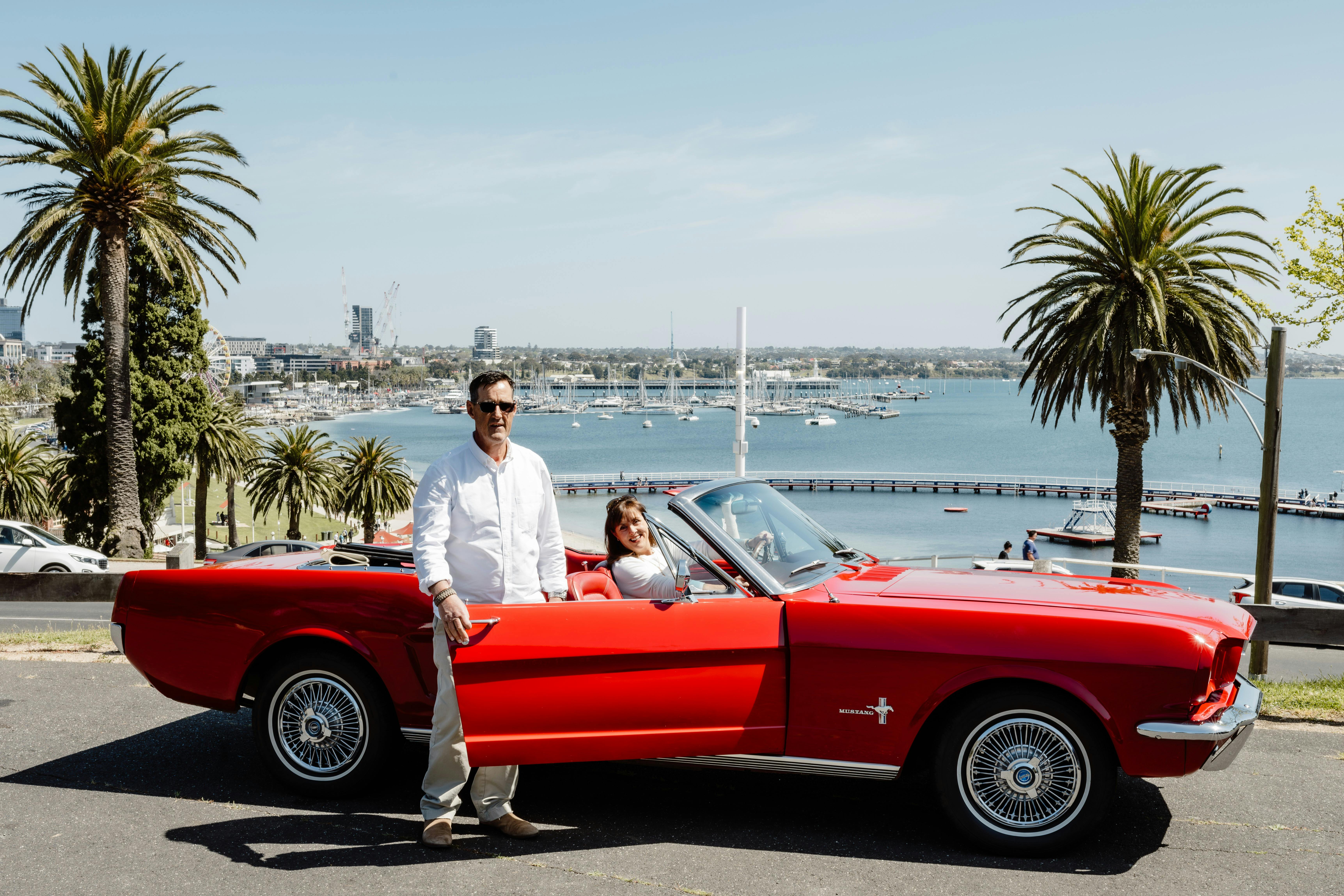 Lisa and Shayne Cunningham owners of Mustabg & Co with  1966 Mustang convertible Geelong background