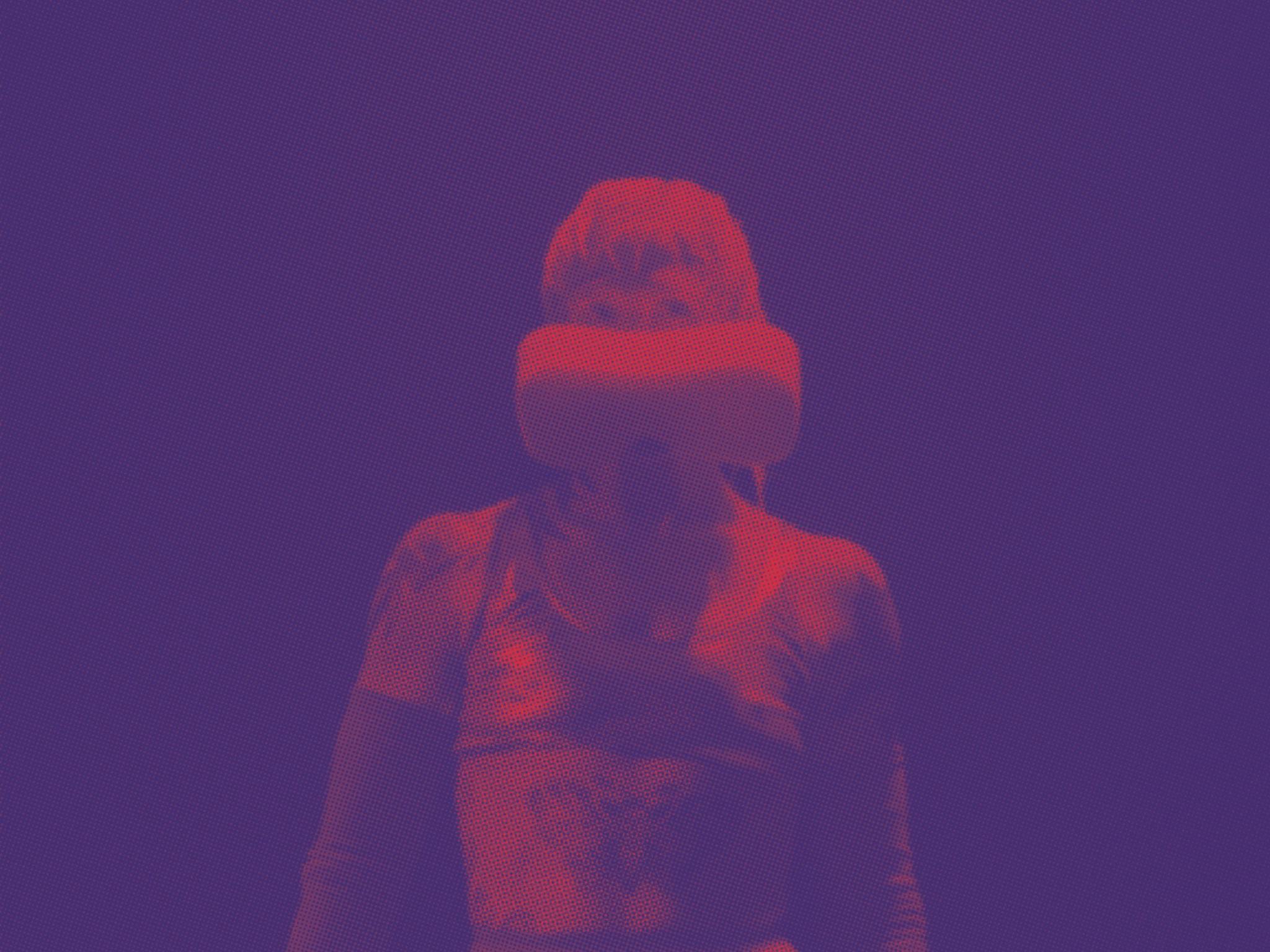 Figure in red and blue light wears a futuristic costume with a sponge-like face covering.