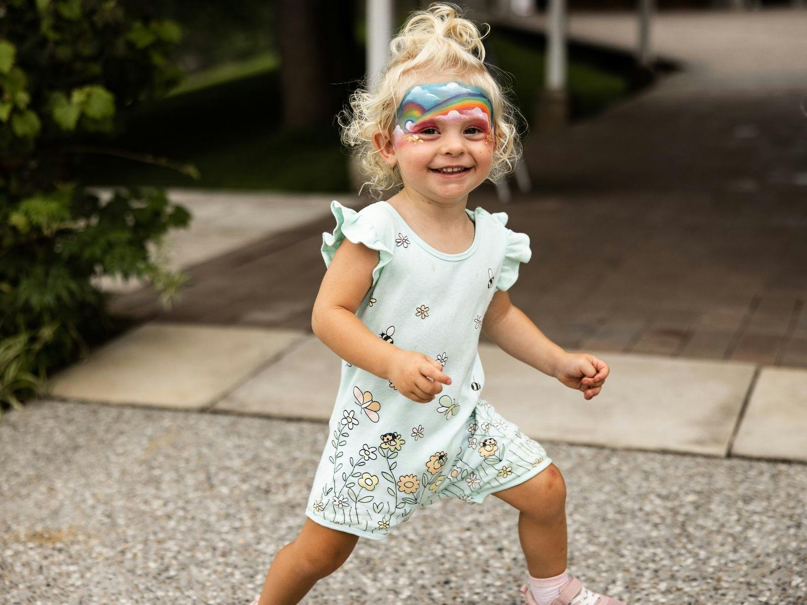 A young excited child standing on the terrace after having her face painted