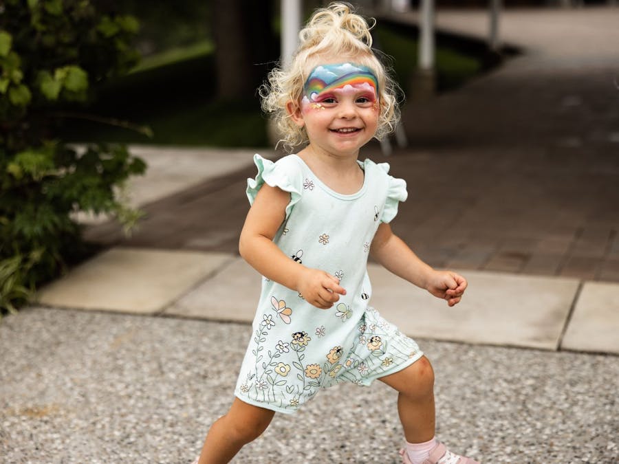 A young excited child standing on the terrace after having her face painted