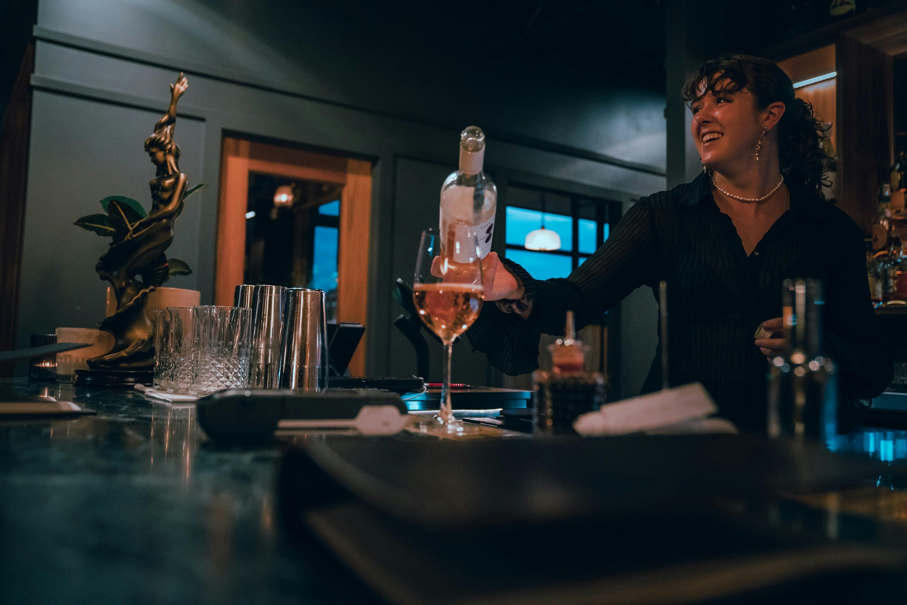Bartender pouring glass of wine
