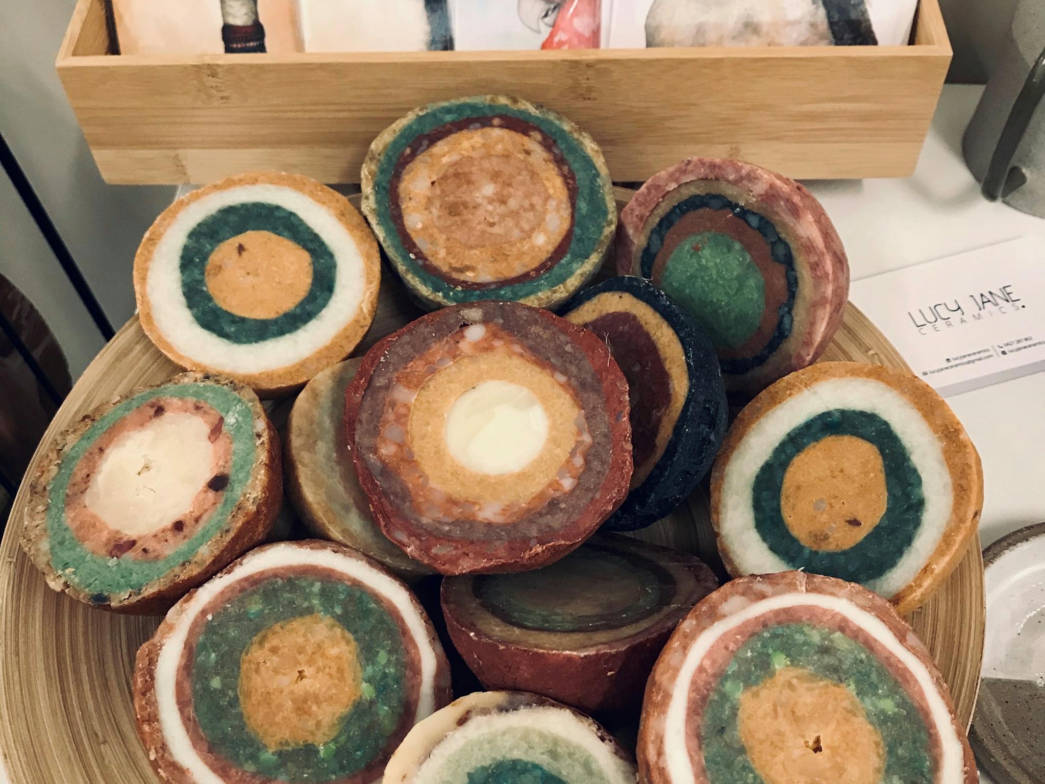 Round multi coloured soaps on display with greeting cards