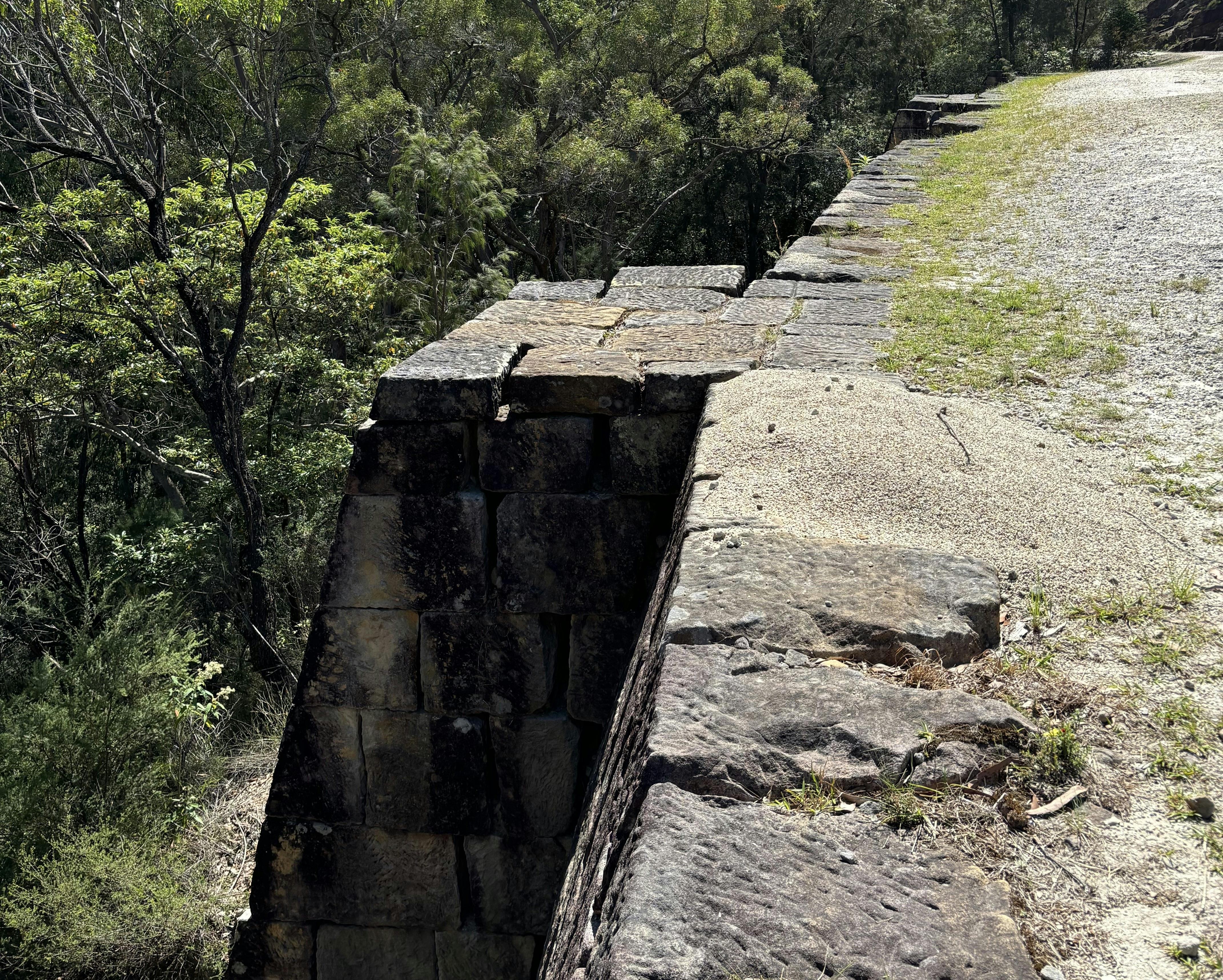 A large stone wall on the edge of a cliff supporting a convict-built road.