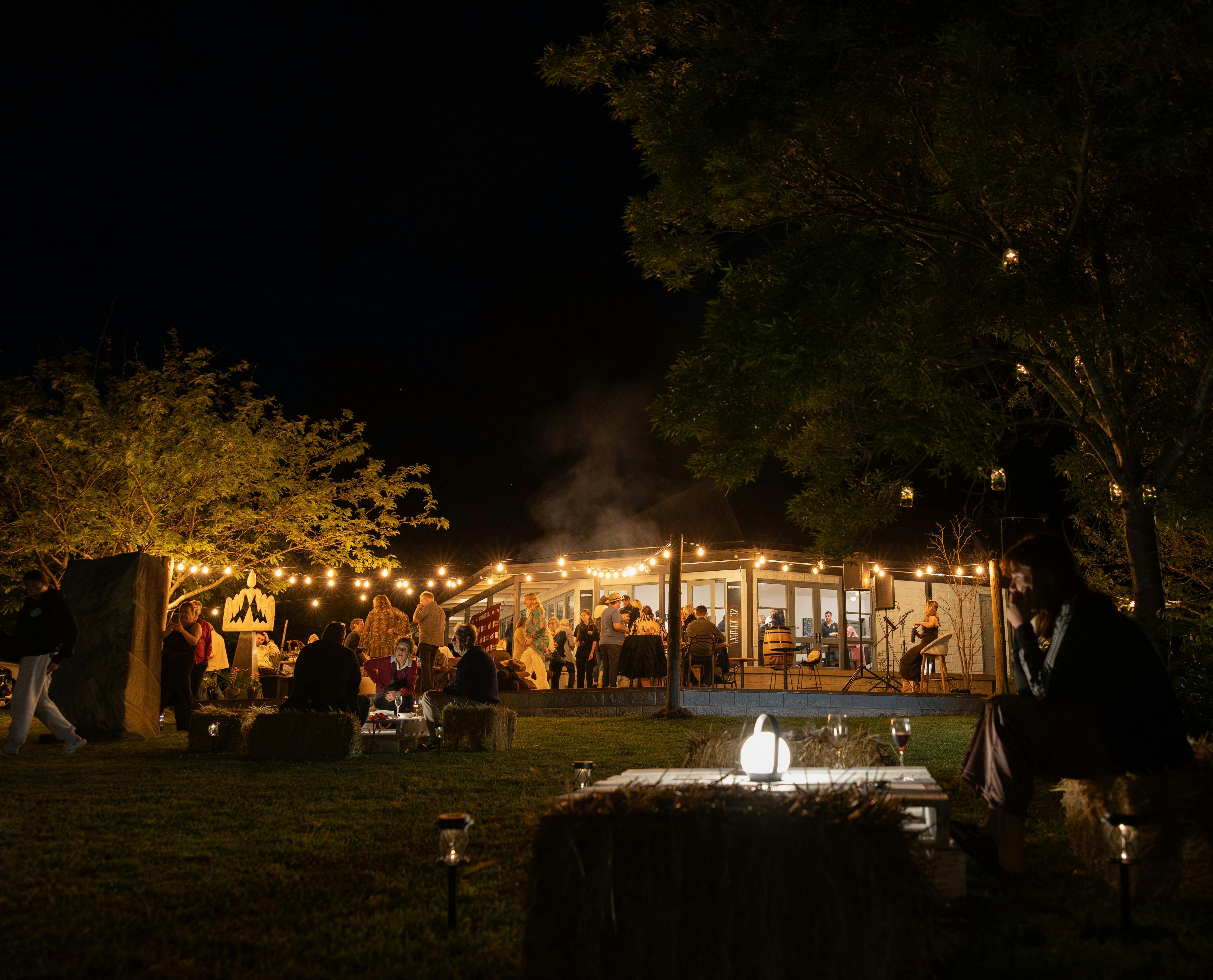 People enjoying wine, fire and live music at an event opening