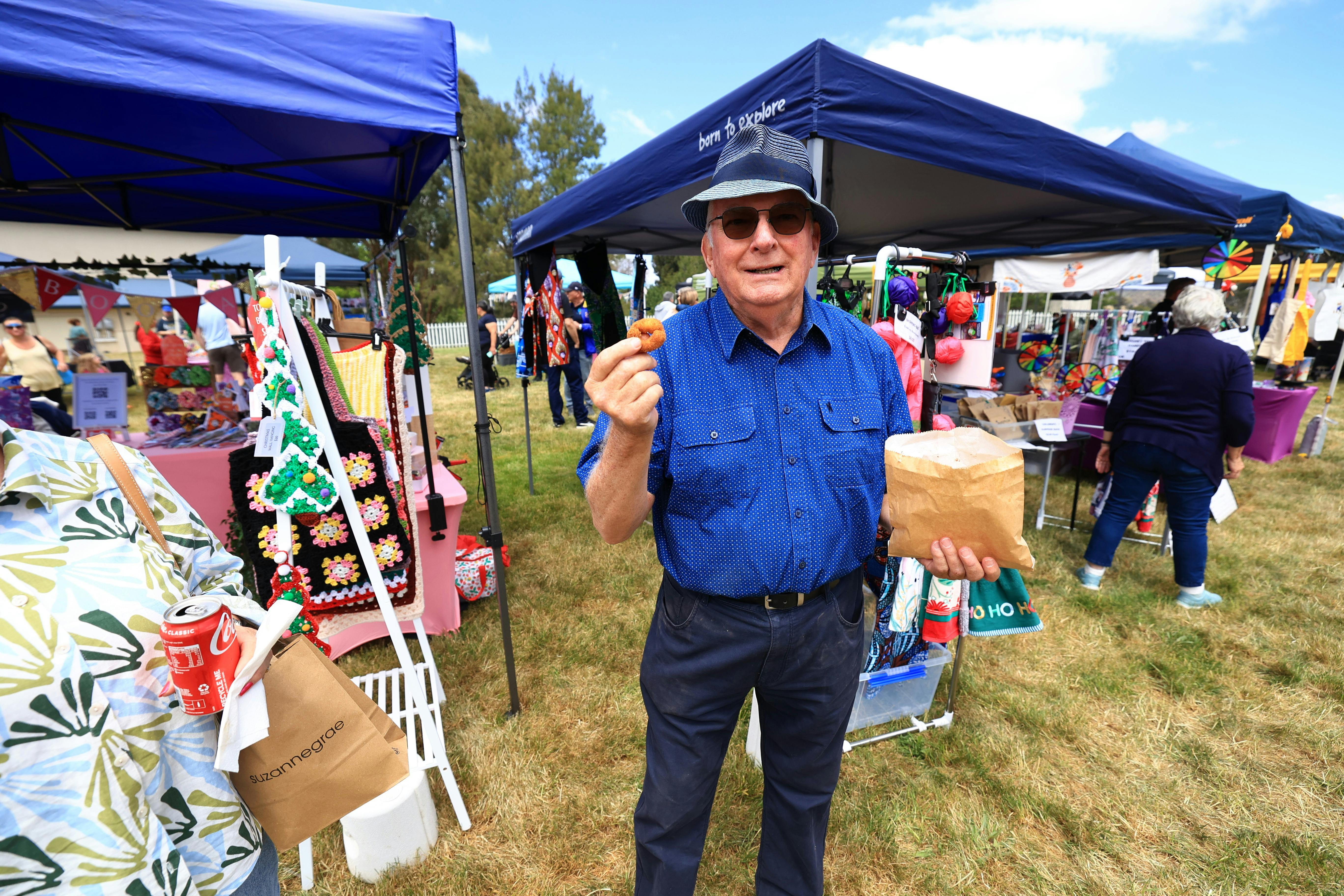 Man standing in front of market stalls