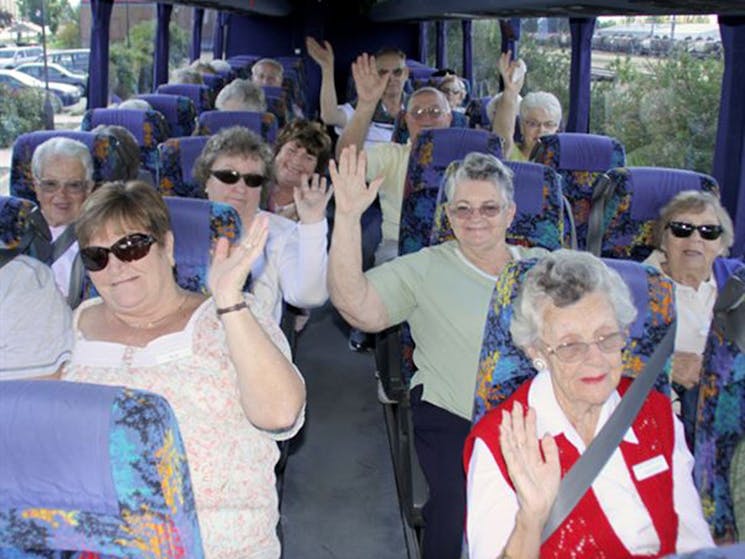 A bus load of people waving to the camera