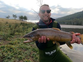 Client holding a large brown trout caught at 28 Gates