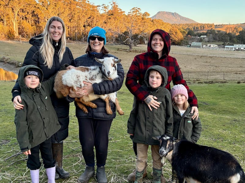 Family holding a goat infront of Quamby Bluff
