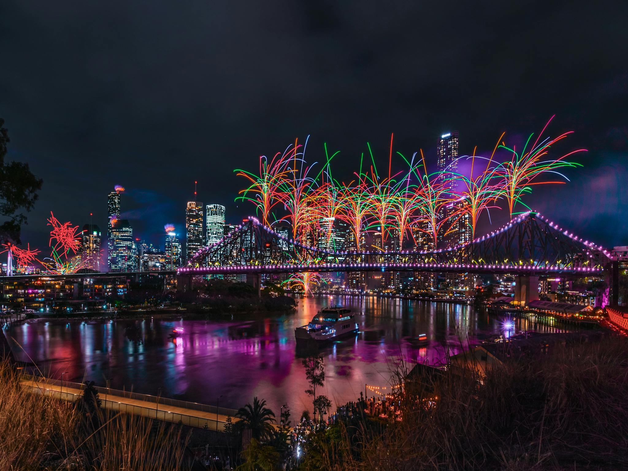 Bright orange and green fireworks explode from the Story Bridge Bright orange and green fireworks explode from the Story Bridge