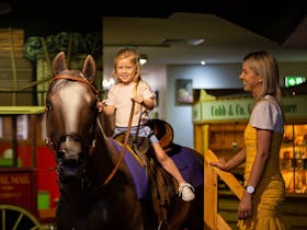 Mum watched daughter ride Socks the replica horse in the Coach Stop play area for kids