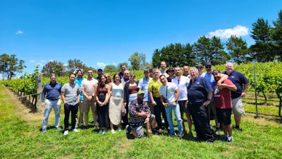 A diverse group of individuals standing together in a vast field, showcasing unity and togetherness.