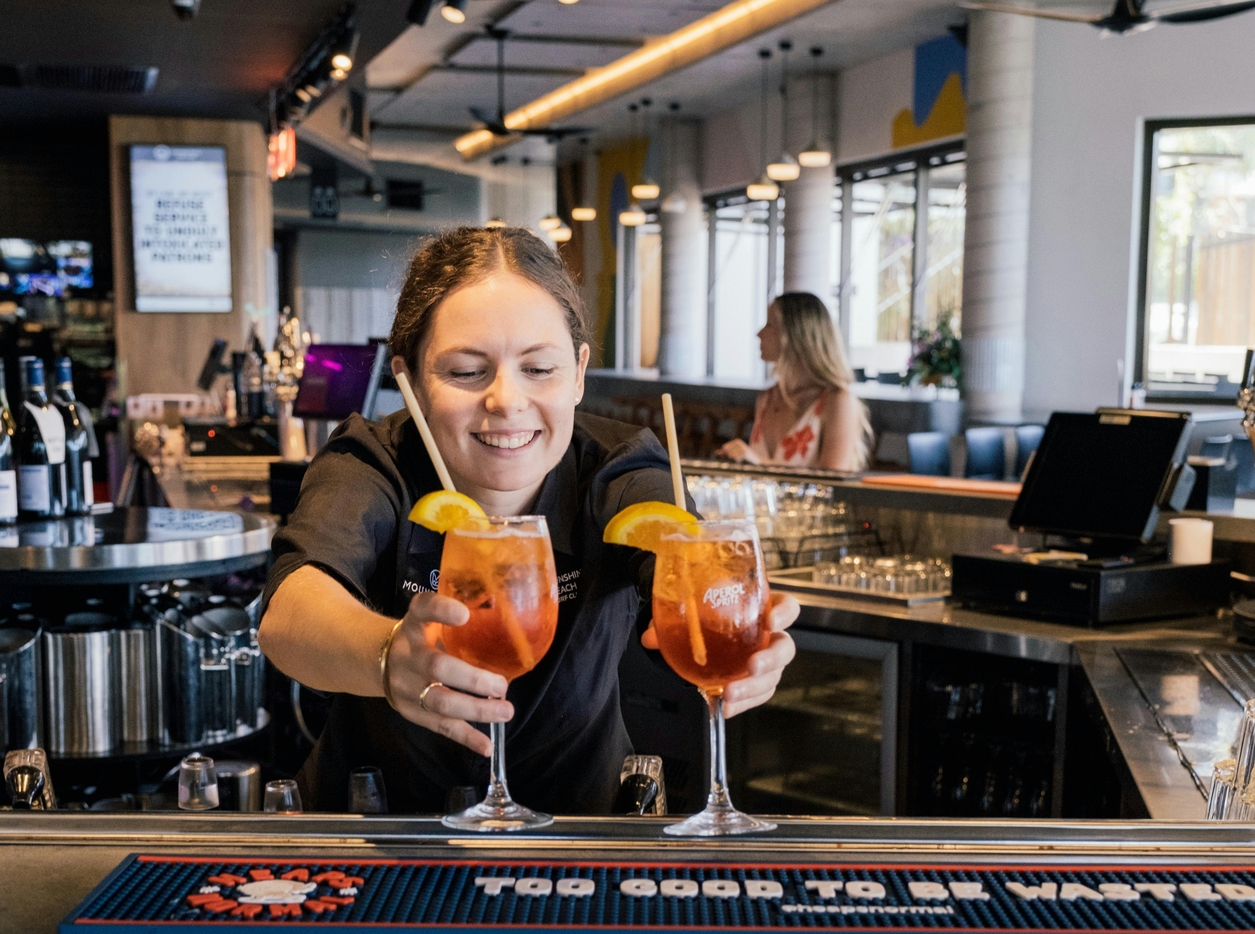 Staff member serving two drinks