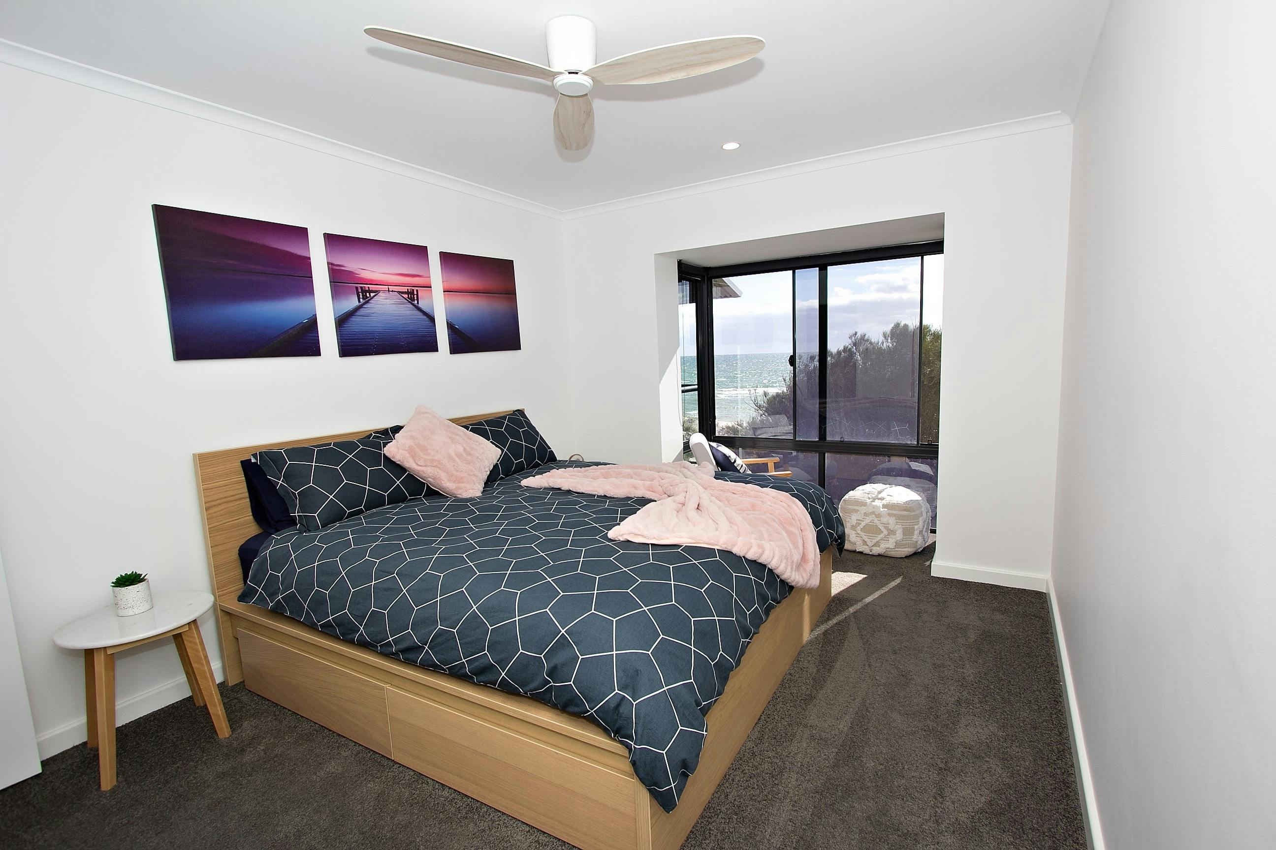 Main bedroom king bed with lounge chair and pouffe to sit and read or relax and watch the ocean