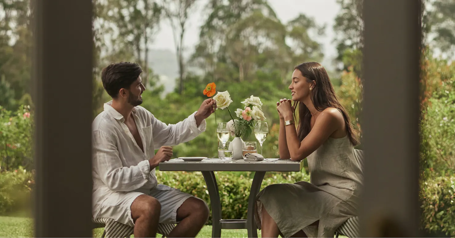 A couple sitting alfresco on Spicers Clovelly Estate lawns