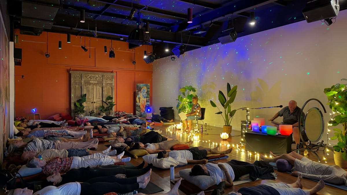 Room of people enjoying sound healing with crystal singing bowls