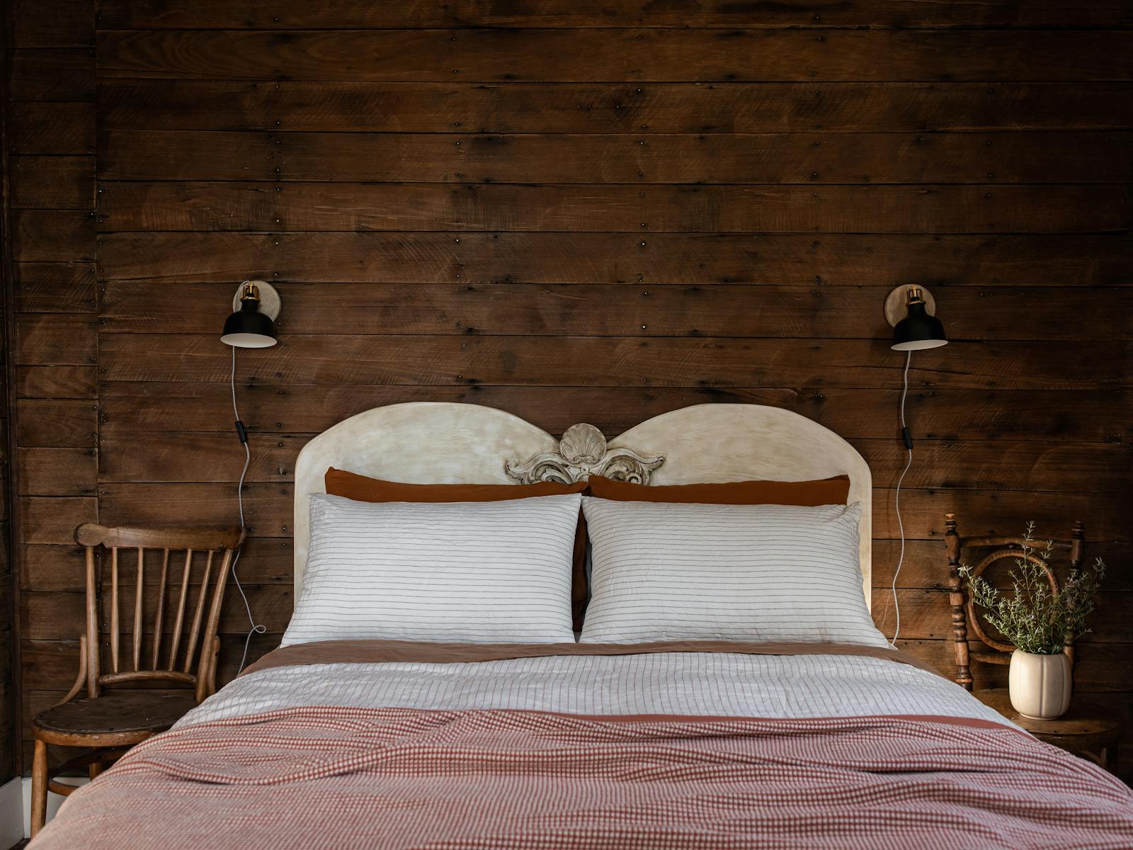 queen sized bed with luxury linen sheets in antique timber room