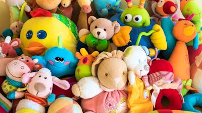 a variety of soft plush toys on display at a market
