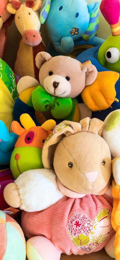 a variety of soft plush toys on display at a market
