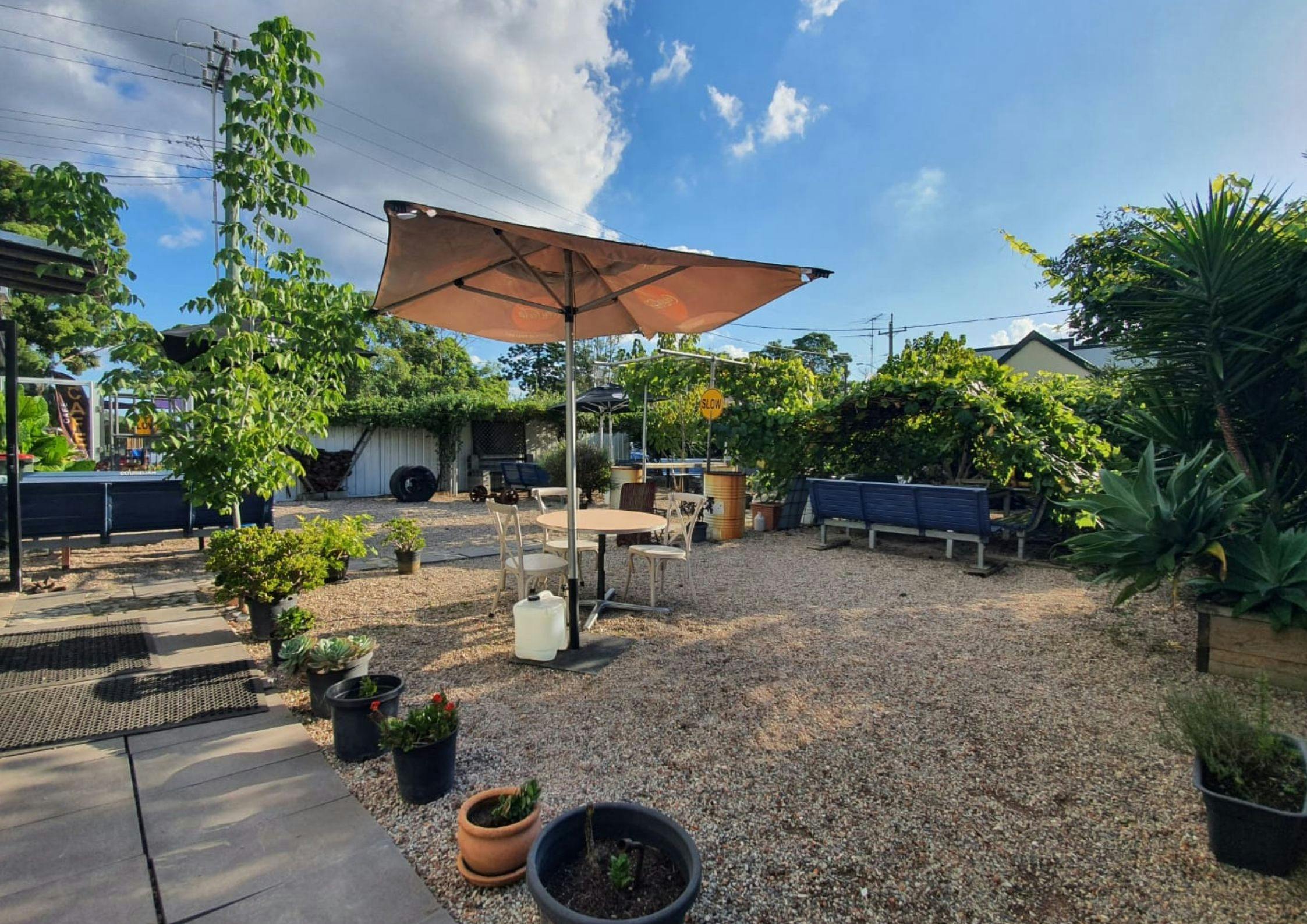 Another different perspective of our garden, potted plants, leading to chairs and up the laneway.