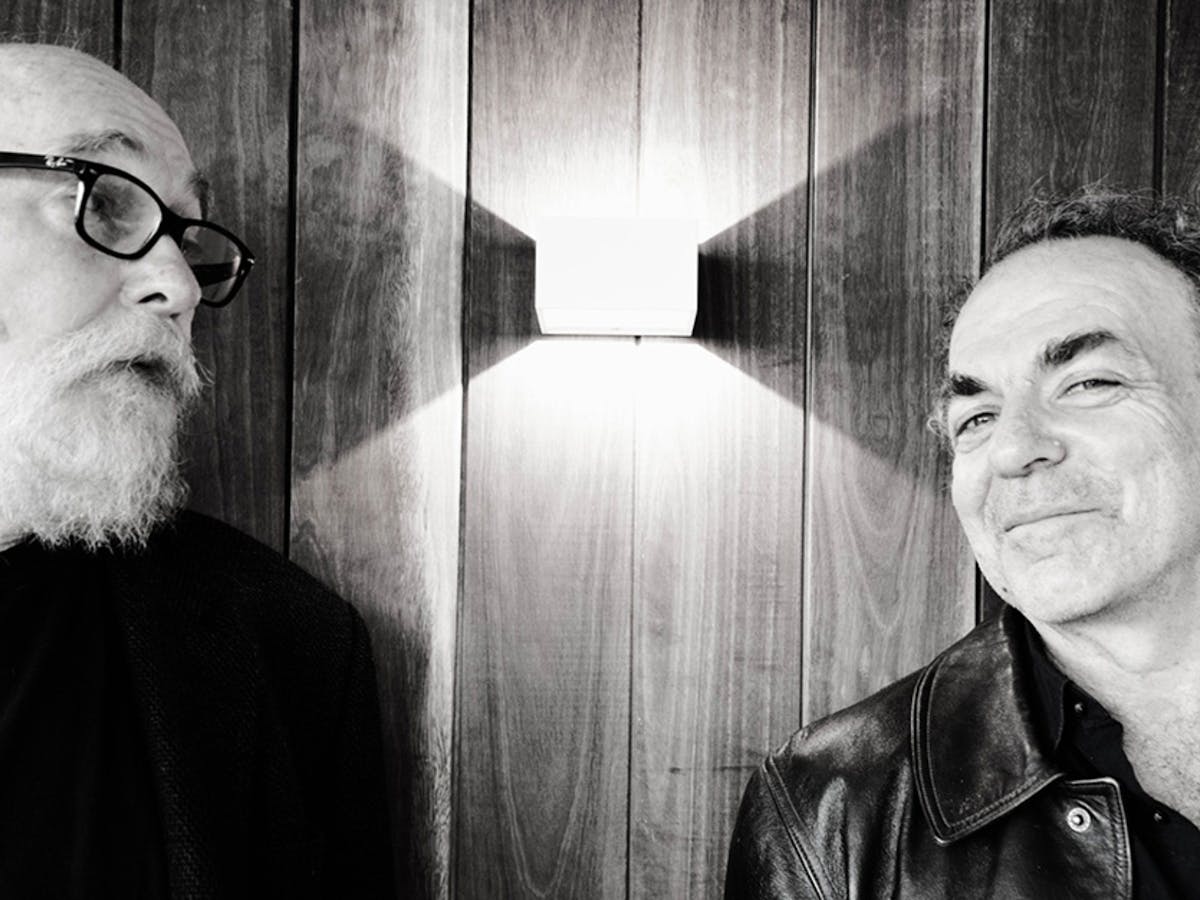 A black and white image of two males. One is looking directly into the camera and one isn't.