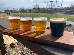 Four glasses of different beers displayed as a paddle