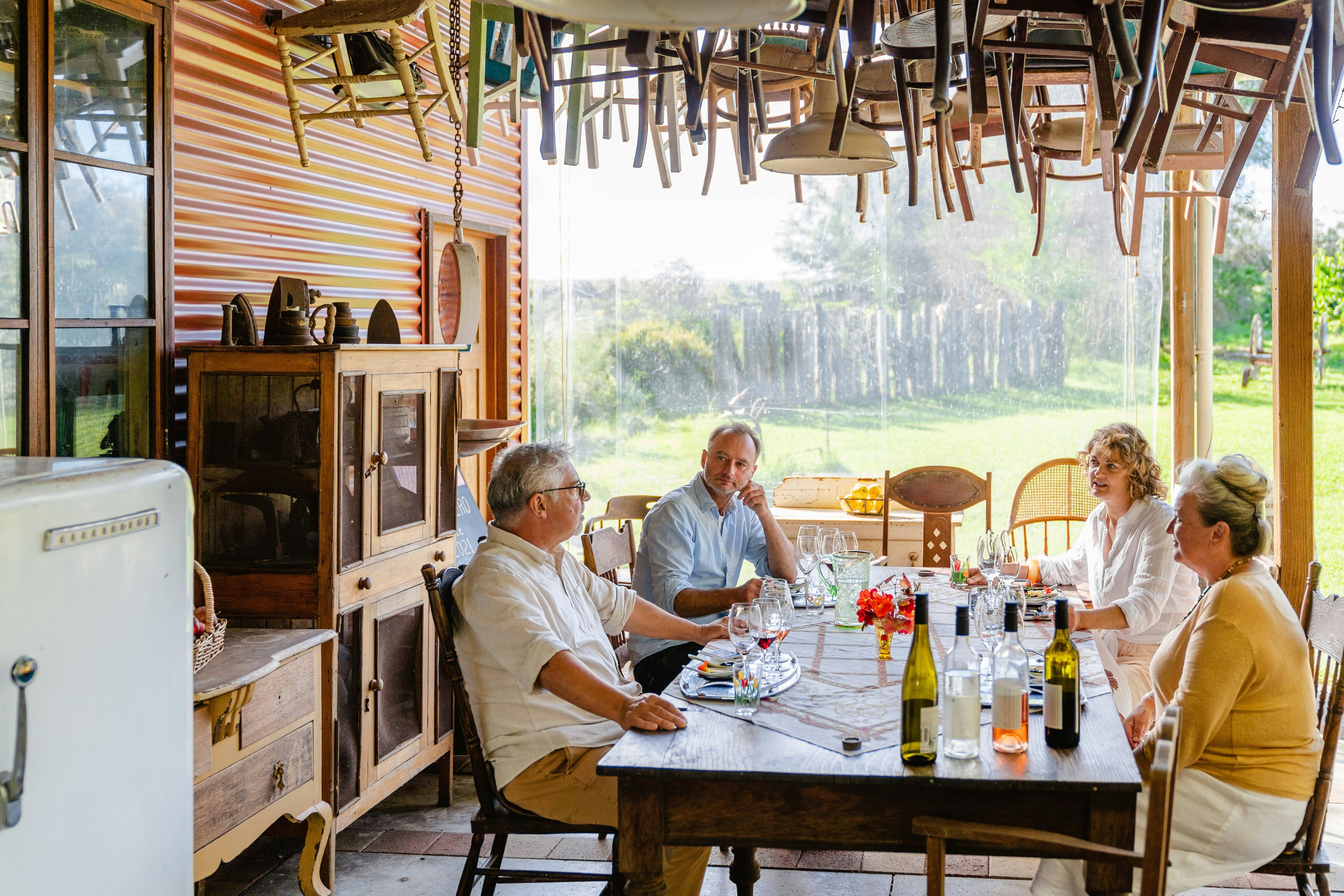 Four people enjoying wine flights in a rustic alfresco setting