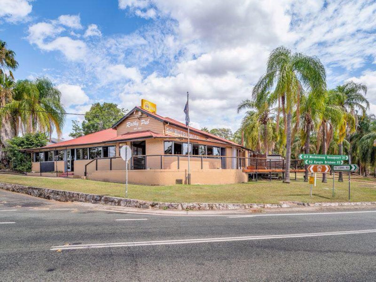 Exterior of a heritage pub surrounded by palm trees