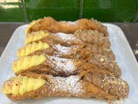 Hand made Cannoli filled with whipped pastry creams with local almond dipped tips.
