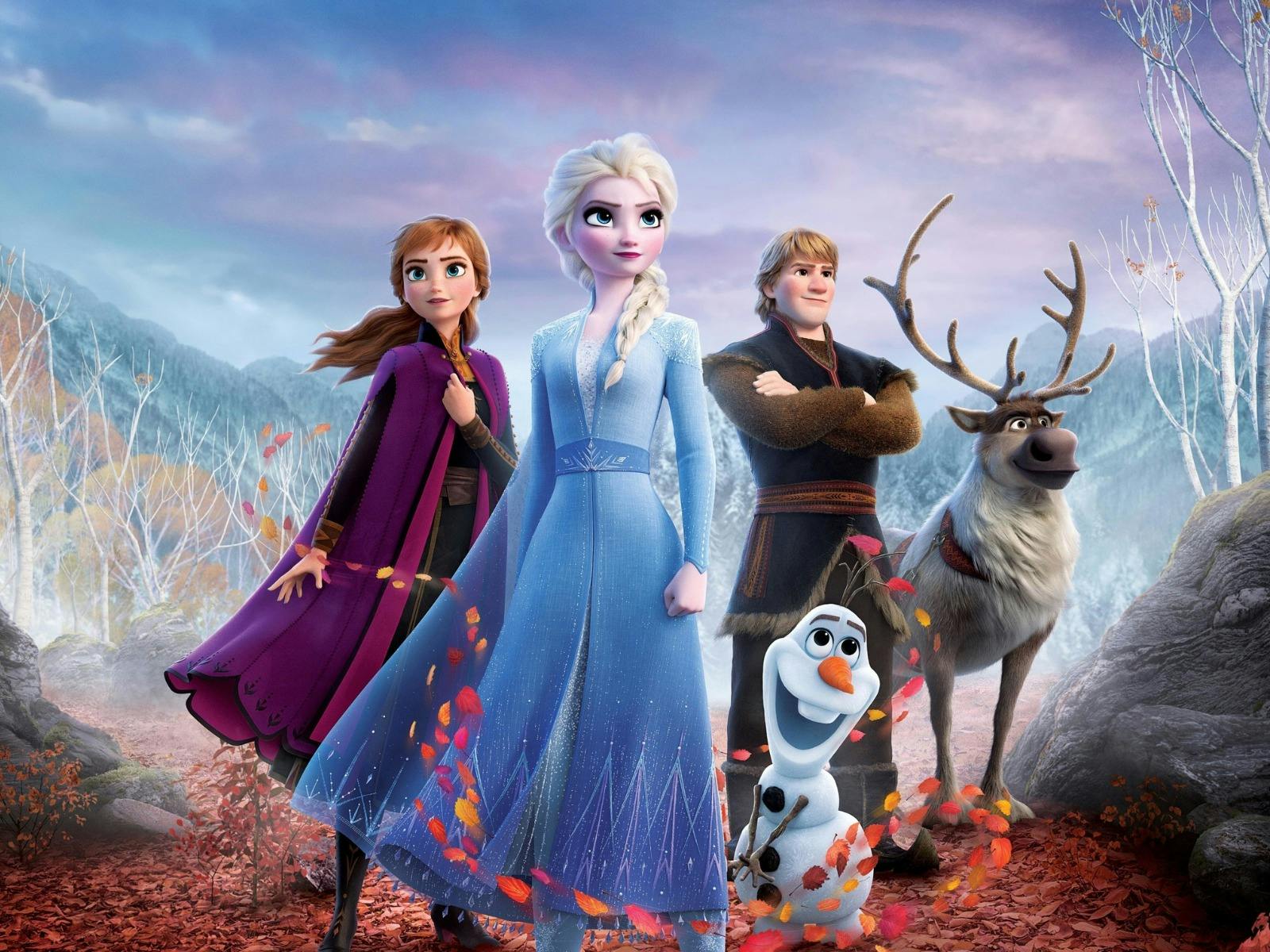 Two women, one male figure with a snowman and deer looking proud standing together