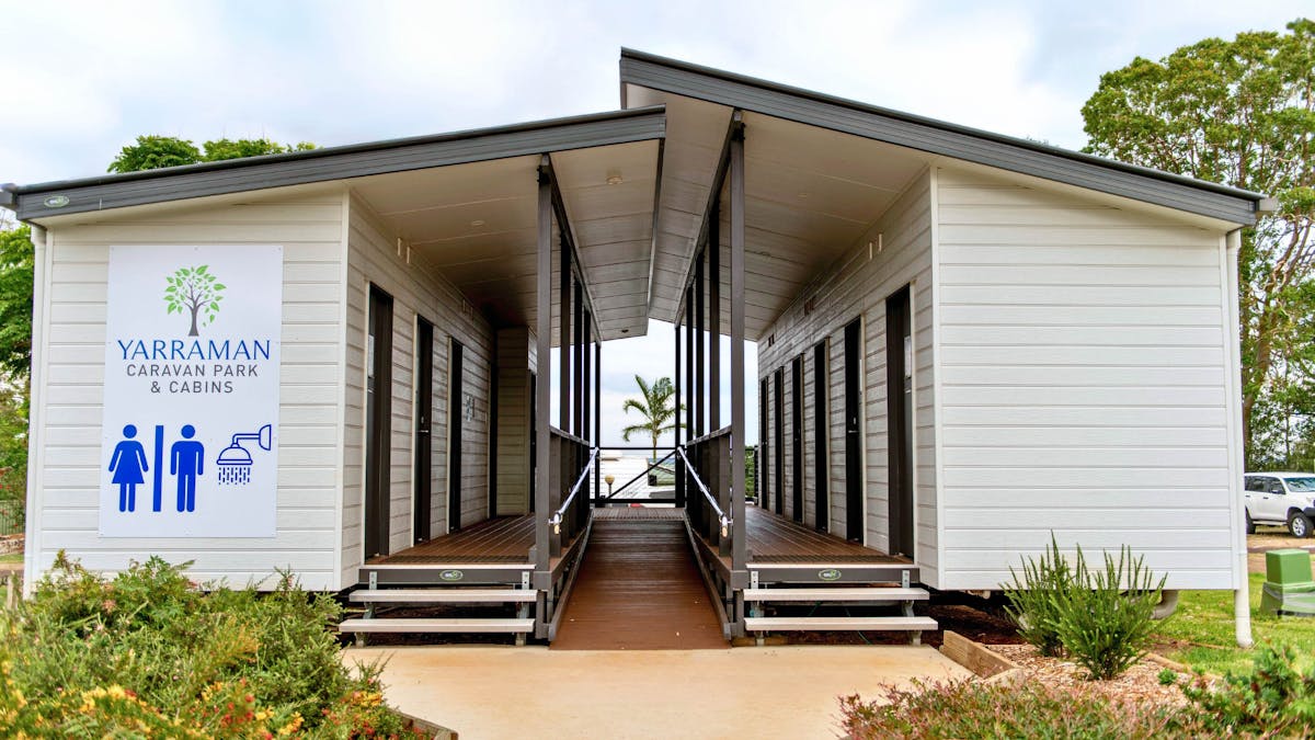 Modern amenities building with accessible ramp and facilities at Yarraman Caravan Park and Cabins.