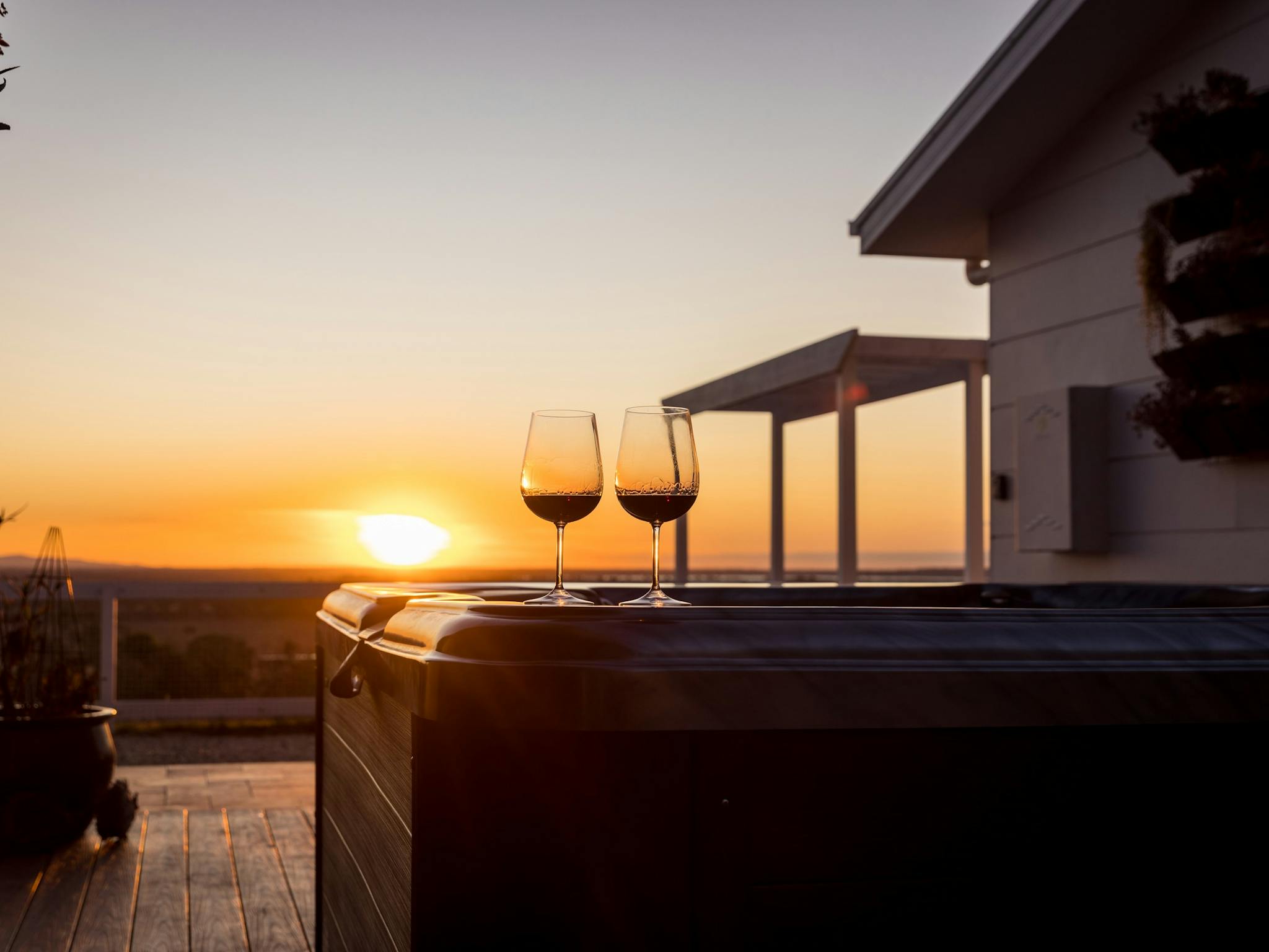 Outdoors, hot tub, horizon view, sunset; two wine glasses on hot tub