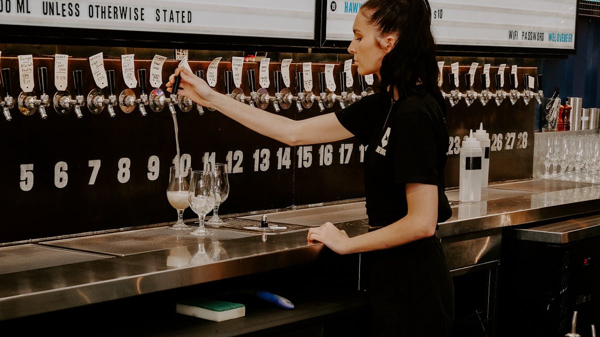 woman pouring beer from kegged tap
