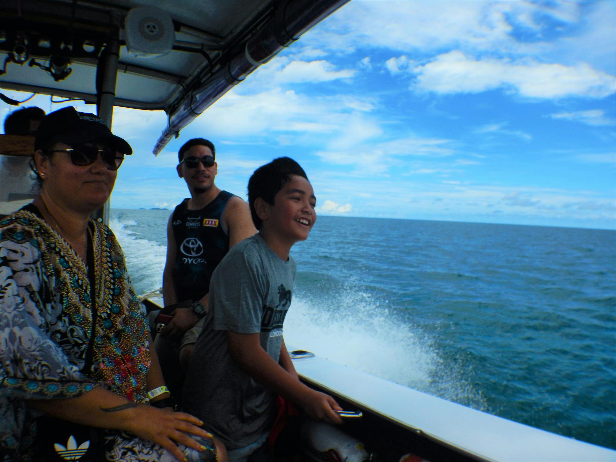 A boy of pacific island appearance feels the wind in his face as a boat cruises tropical seas.a A boy of pacific island appearance feels the wind in his face as a boat cruises tropical seas.a